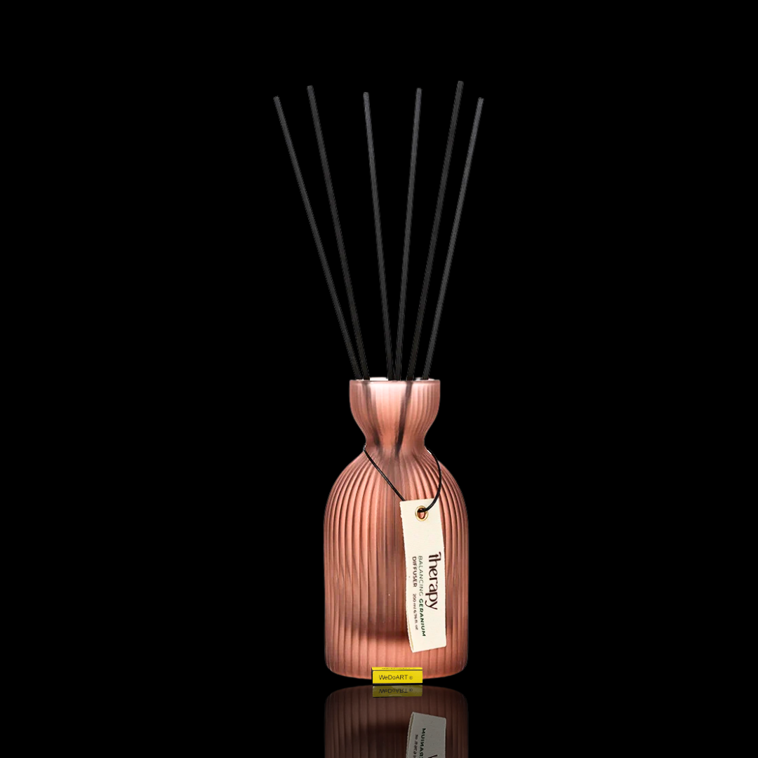 Aufgestellter LALINE Geranium Fragrance Diffuser im gerippten Glasgefäß in Roségold mit schwarzen Stäbchen und cremefarbenem Anhänger