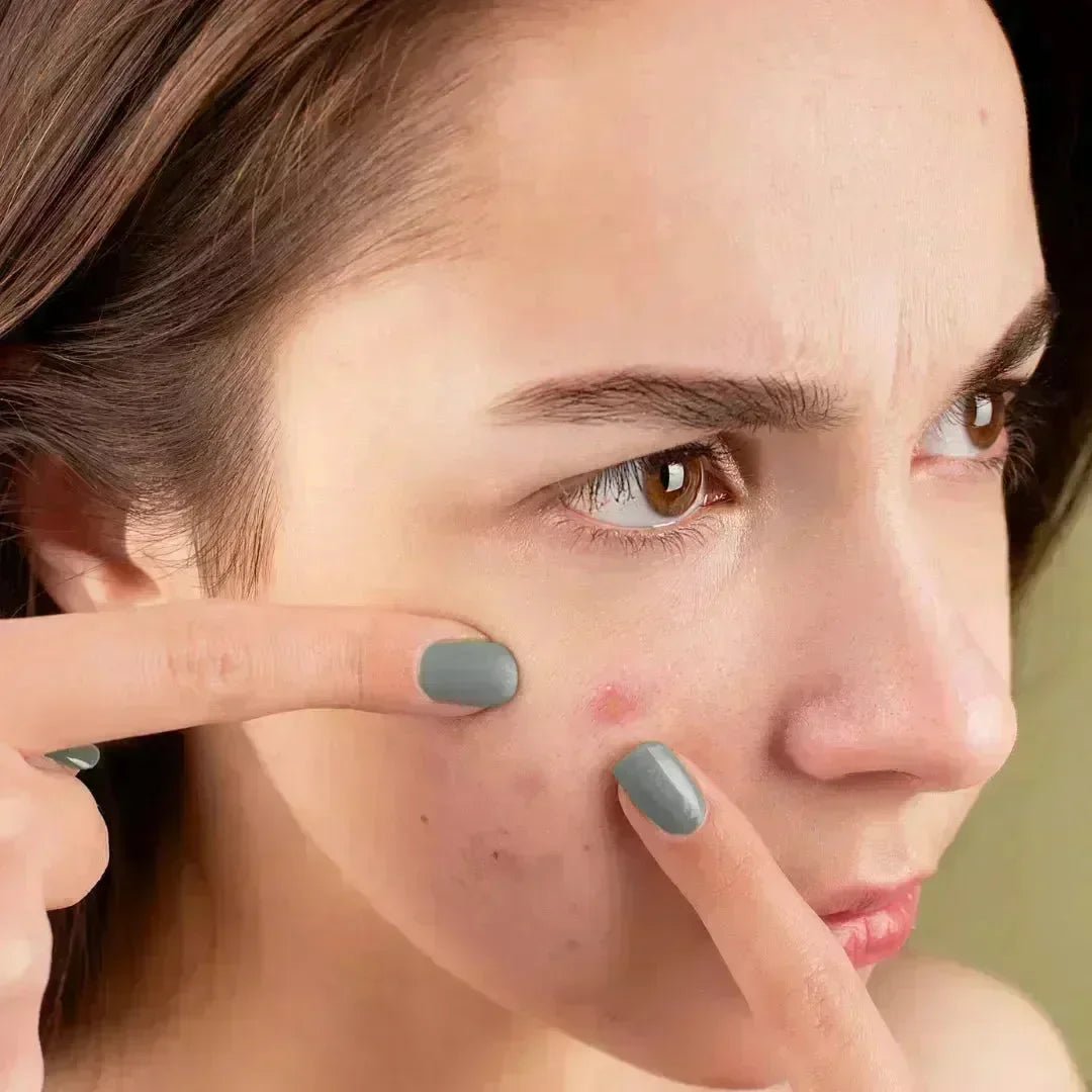 Woman looking closely at a blemish on her cheek