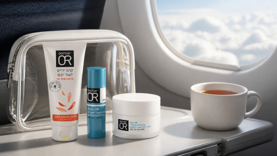 Doctor OR hand cream, lip balm and face moisturizer on an airplane tray table beside a clear travel pouch and a cup of tea
