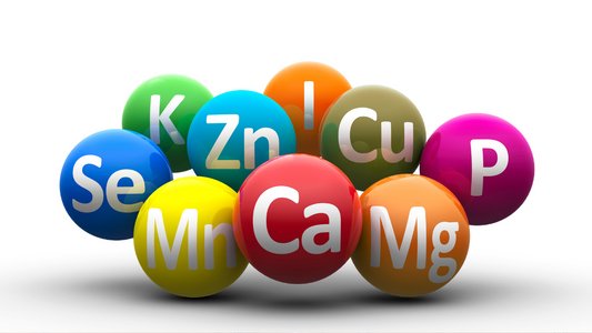 Colorful spheres with vitamin and mineral symbols like Ca, Mg, Zn, Se, ideal for skincare health