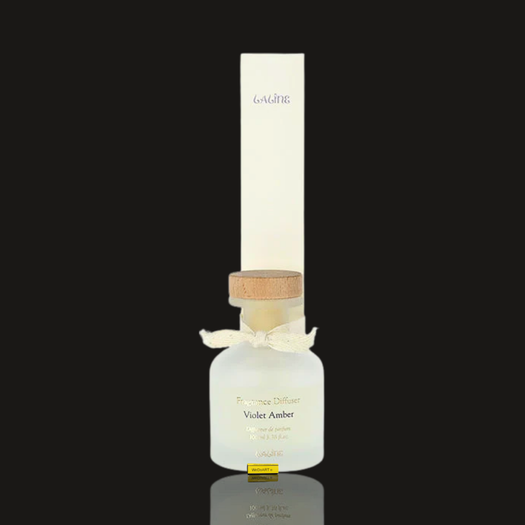Laline Violet Amber reed diffuser 100 ml: cream box standing behind a frosted white glass bottle with wood stopper and ribbon
