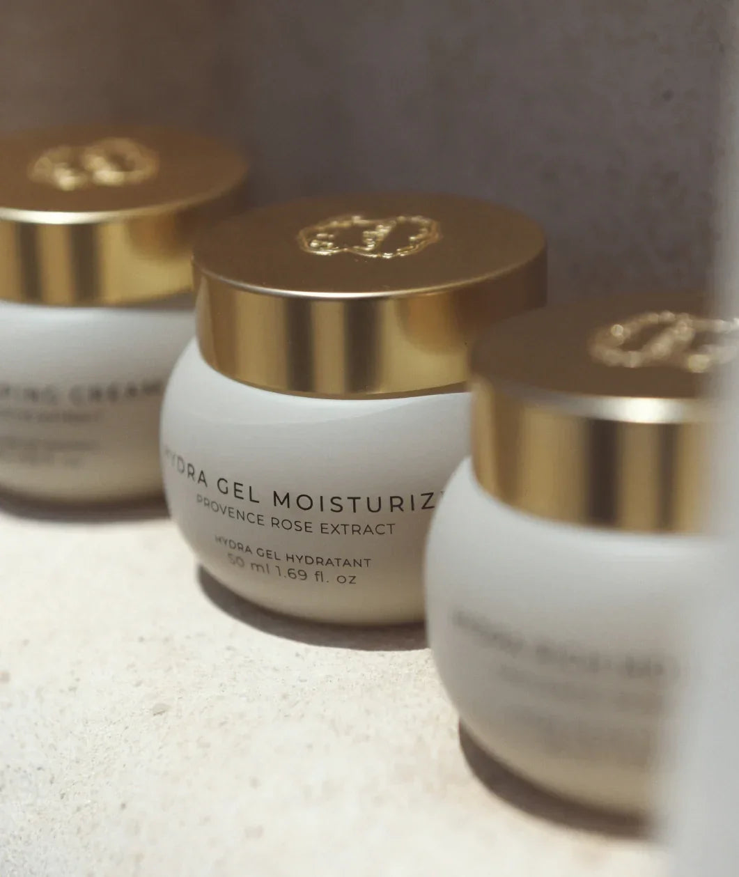 Laline Rich Sleeping Cream with shiny gold lids arranged on a light beige surface. The center jar is in focus and reads 'HYDRA GEL MOISTURIZING ROSE EXTRACT'.