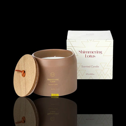 Shimmering Lotus scented candle in a brown jar with a wooden lid and matching white gift box.
