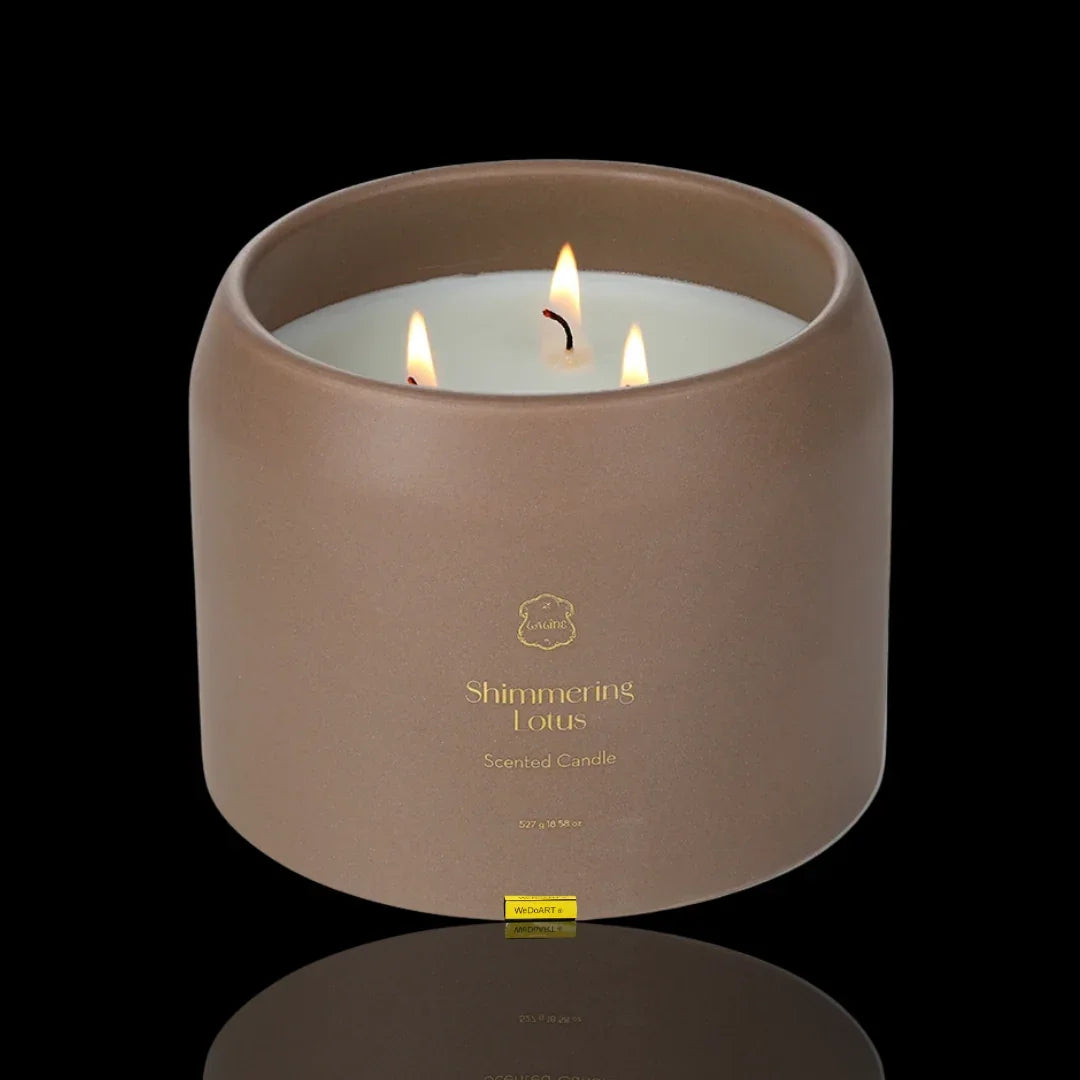 Shimmering Lotus scented candle in a matte brown ceramic jar with three lit wicks