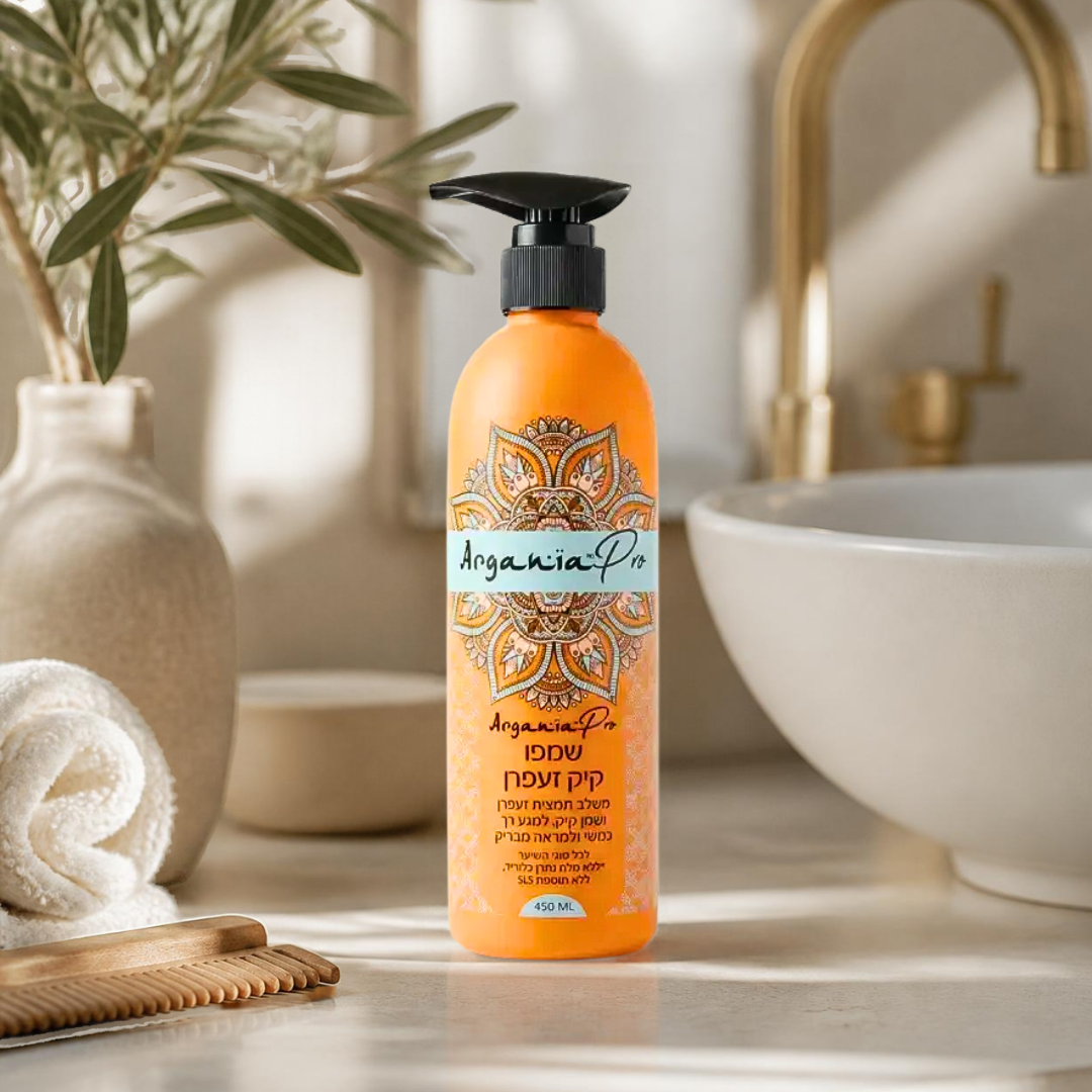 Orange Castor Saffron Shampoo bottle beside a folded towel, wooden comb and white basin in a bright bathroom