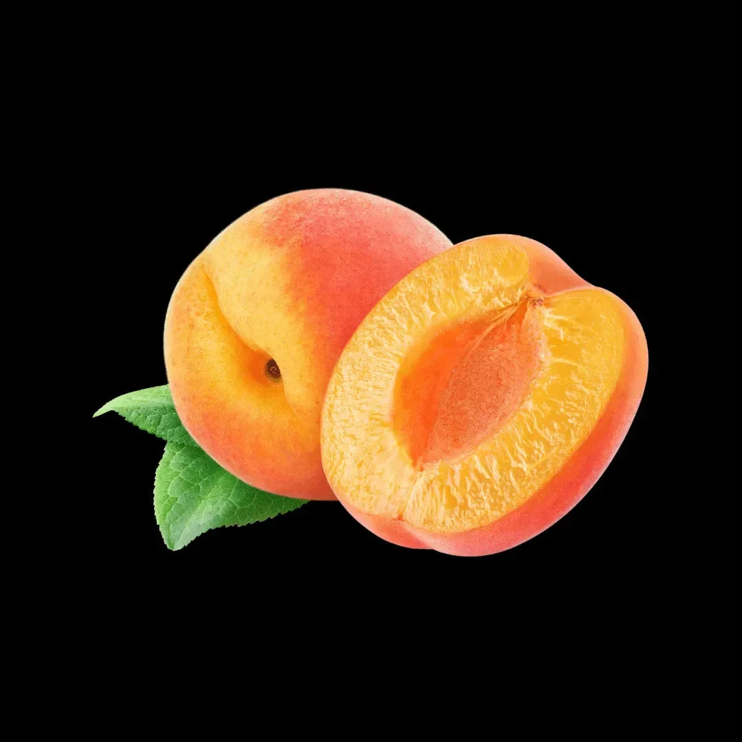 Whole and halved ripe peaches with green leaves on a black background