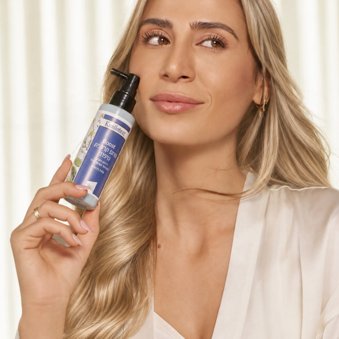 Woman holding the Kamilotract Boost Scalp Serum spray bottle beside her face