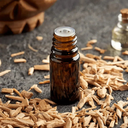Dark bottle standing among light cedar wood shavings
