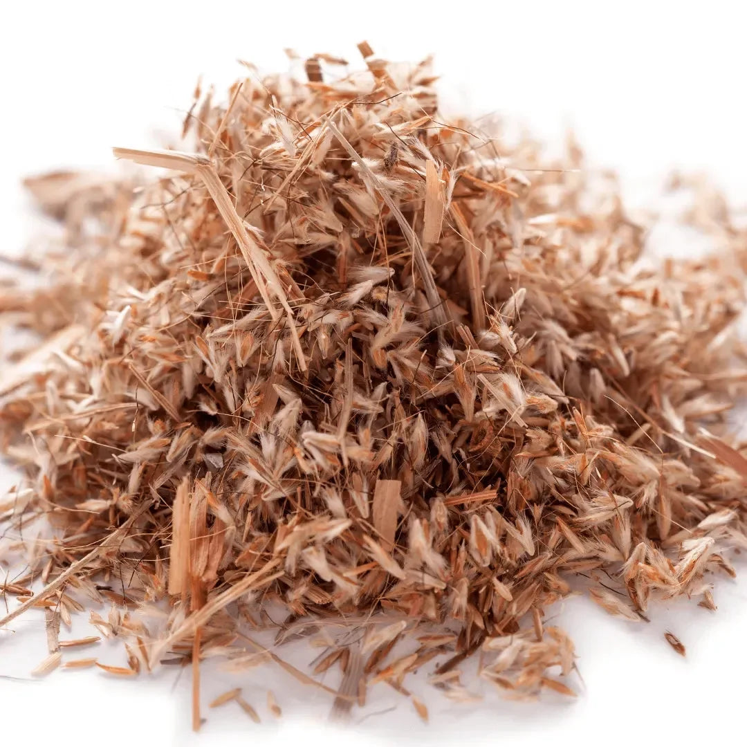 Pile of dried light brown plant fibers on a white background