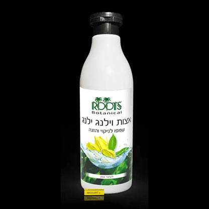 Roots ylang ylang shampoo 500 ml bottle beside fresh ylang flowers
