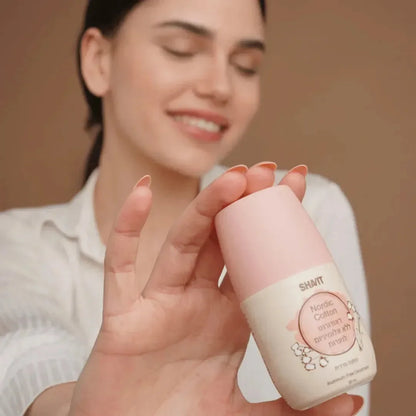 Smiling girl holding a SHAVIT Nordic cotton roll-on deodorant bottle with a pink cap