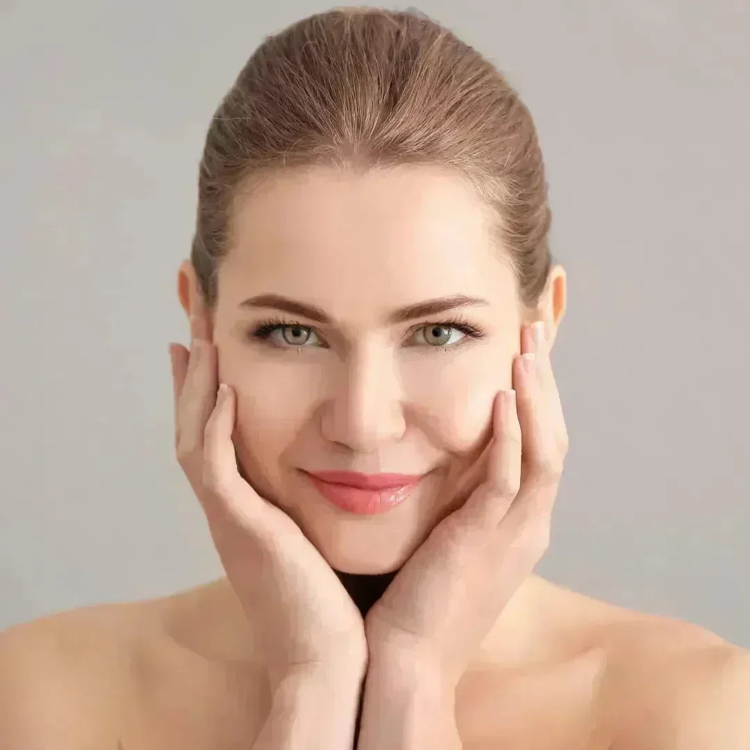 Smiling woman with her hands on her cheeks and a soft, fresh complexion