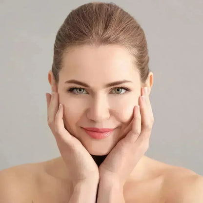 Smiling woman with her hands on her cheeks and a soft, fresh complexion