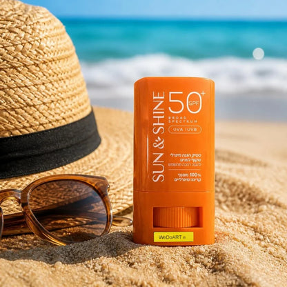 Sun & Shine Clear Mineral Face Sunscreen Stick SPF 50+ standing in beach sand beside a straw hat and sunglasses